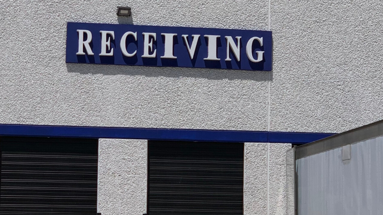 Canales Furniture, Arlington TX — full EIFS signage assembly: a foam holder board is shaped to size, skinned with fiberglass mesh and base coat, finished in cobalt color coat, then mounted to the wall. The dimensional white letters are cut from EIFS foam, coated the same way for a hard, weatherproof shell, and adhered to the panel — giving a seamless, all-EIFS sign that won't rust, rot, or fade like metal or wood signage.